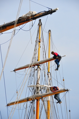 Dudes working in the rigging of tall ships at the harbour