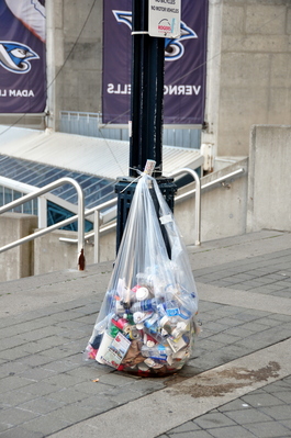 All garbage cans (and other street furniture) have been removed, plastic bags tied to poles are the replacement