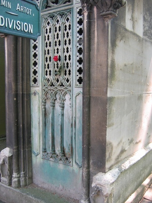 An old tomb with a single fresh rose in the door