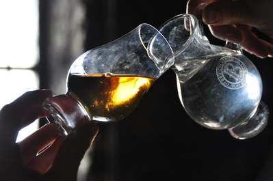 Our guide carefully pouring water below the oils in the whisky to show the separation